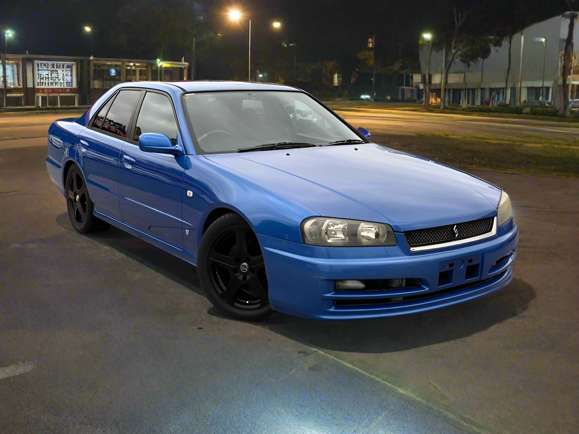Blue car parked in a lot at night