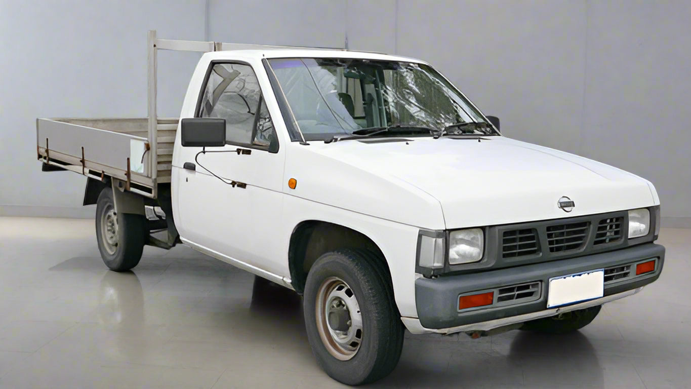 White D21 Nissan Navara Ute parked inside showroom