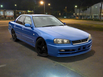 Blue car parked in a lot at night